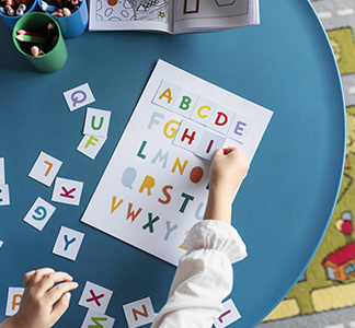 top-view-kid-learning-letters-at-kindergarten